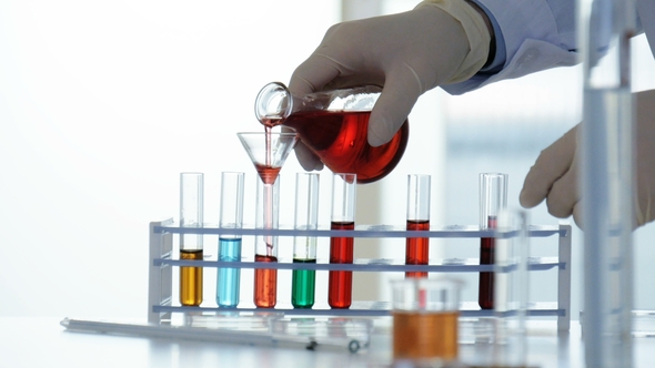 Lab Worker Pours Chemicals From a Flask Into a Test Tube