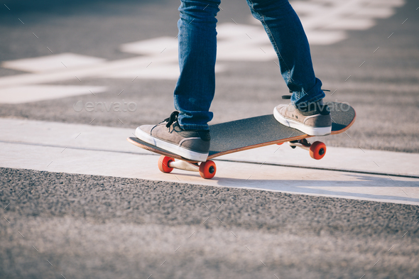 Skateboarder riding skateboard pass a crack on street Stock Photo by lzf
