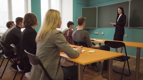 Woman Teacher Talking To Students During a Lesson in Classroom