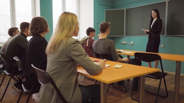 Woman Teacher Talking To Students During a Lesson in Classroom alt
