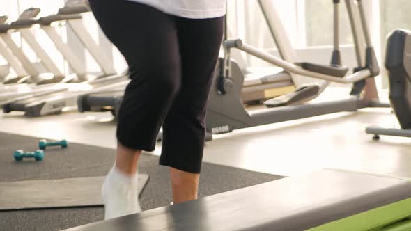 Pensioner Elderly Woman in a Gym on Step Platform
