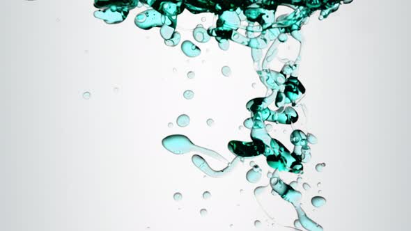 Isolated Turquoise Oil Bubbles Floating in Water Tank
