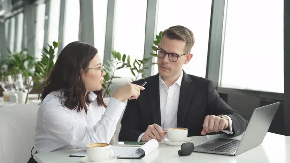 Young Business Lady in Formal Shirt and Eyeglasses Talking with Business Partner Seriously Looking