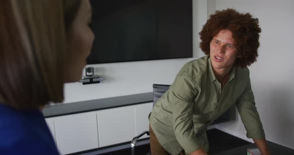 Diverse male and female business colleagues in discussion in meeting room alt