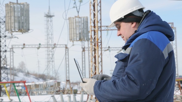 Engineer With Portable Computer at Electric Power Station