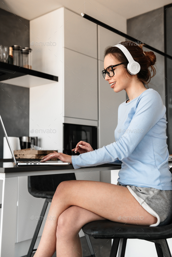 Portrait of a cheerful young woman in headphones - Stock Photo - Images