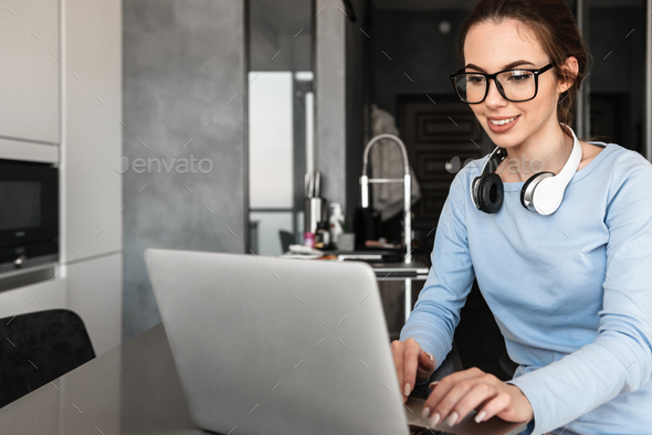 Portrait of a smiling young woman in headphones - Stock Photo - Images
