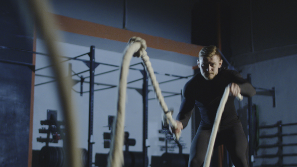 Athlete Working Out with Heavy Ropes in Gym alt