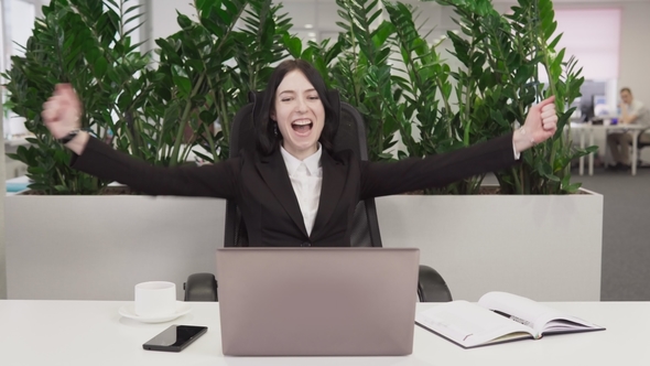 Business Woman See Good News on the Laptop, Laughs and Rejoicing in Success
