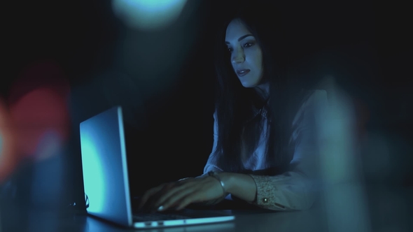 Woman Working on Laptop at Night at Home