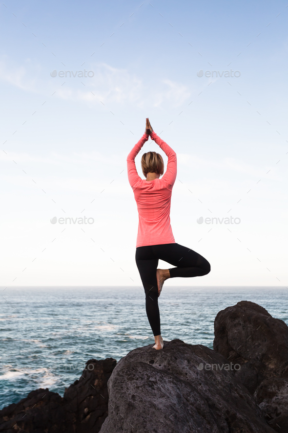 Woman meditating in yoga vrksasana tree pose - Stock Photo - Images