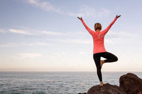 Woman meditating in yoga vrksasana tree pose - Stock Photo - Images
