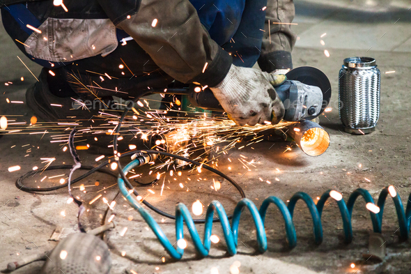 mechanic cuts new pipe for corrugation muffler - Stock Photo - Images