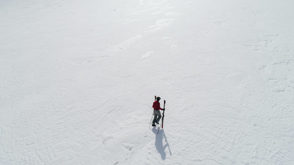 Skier Hiking to Mountain Summit alt