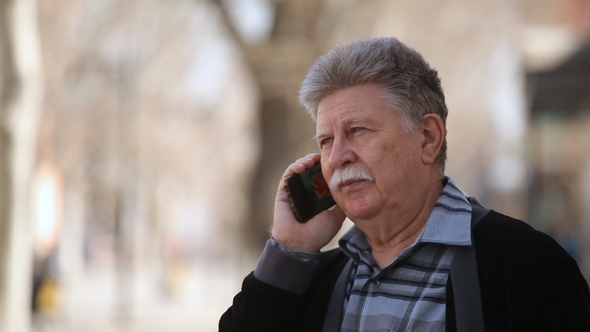 Senior Man with White Moustache Talking on Phone with His Family in Spring