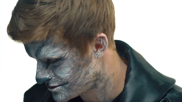 Handsome Guy with Wolf Makeup on Face Turns Head and Looks Forward alt