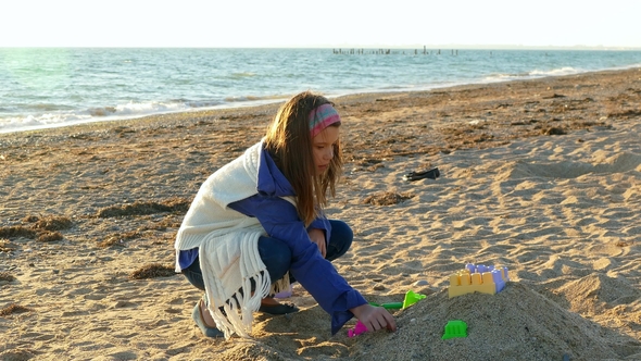 The Girl Creates a Sand Castle