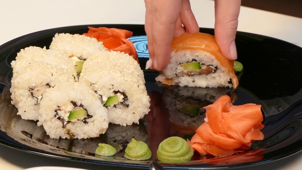 A Cook Makes a Set of Sushi Rolls on a Plate