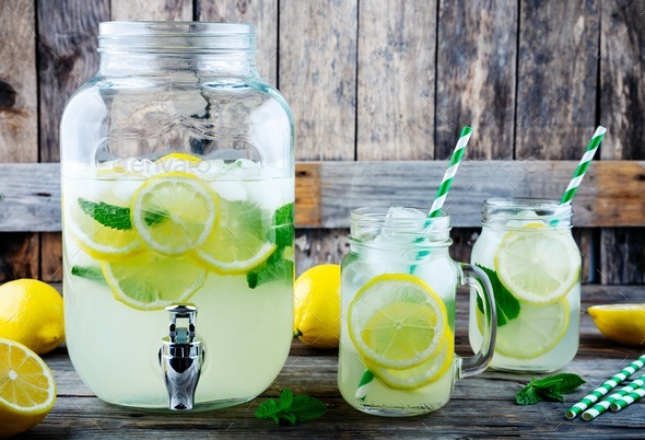 Homemade lemonade with mint, ice, and fresh lemon slices in mason jar Stock Photo by nblxer