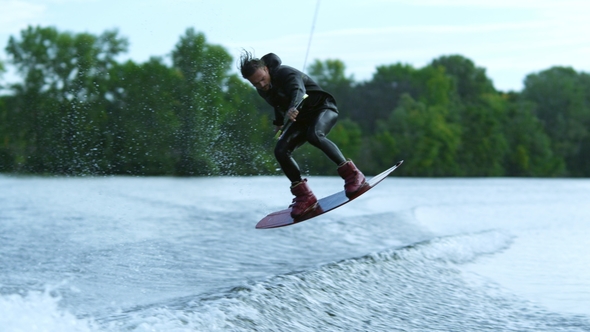 Wake Board Rider Jumping High Over water.Wake Surfing Rider on Water alt