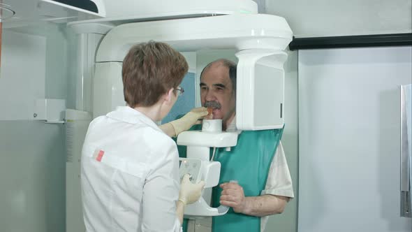 Young Woman Dentist Peparing Patient for Analyzes a Dental Panoramic X-ray Film in Clinic alt