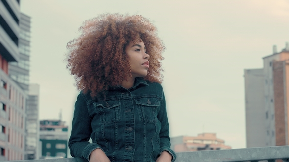 Black Mixed Race Woman with Big Afro Curly Hair in Outdoor City