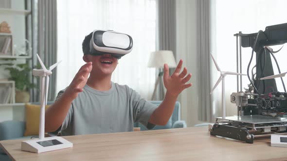 Boy Sitting At The Table And Wearing Vr Glasses While Experimenting With Wind Turbine Model At Home alt