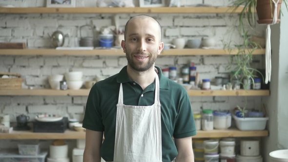 Portrait of Male Ceramist, Who Is Standing in His Studio and Watching To the Camera alt