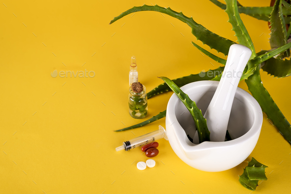 Aloe vera leaf, white mortar full of chopped aloe and bottles of aloe gel or infusion. - Stock Photo - Images