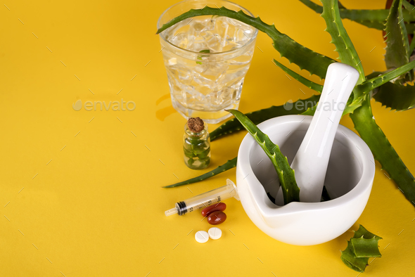 Aloe vera leaf, white mortar full of chopped aloe and bottles of aloe gel or infusion. - Stock Photo - Images