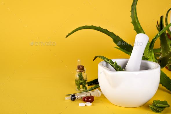 Aloe vera leaf, white mortar full of chopped aloe and bottles of aloe gel or infusion. - Stock Photo - Images