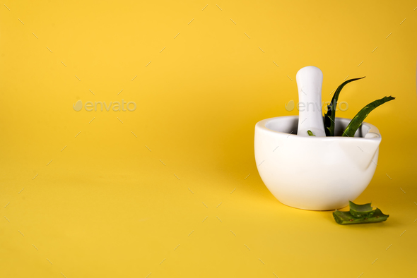 Aloe vera leaf, white mortar full of chopped aloe and bottles of aloe gel or infusion. - Stock Photo - Images