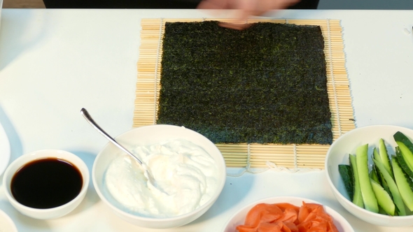 The Cook Is Laying Boiled Rice on Nori
