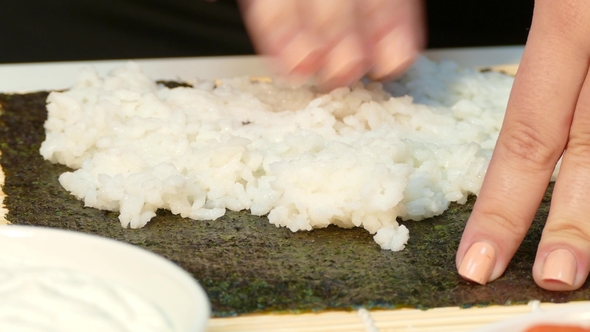 Chef Hands Kneading Rice on Nori Sheet