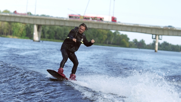 Joyful Man Wakeboarding on City River. Extreme Entertainment on Water alt