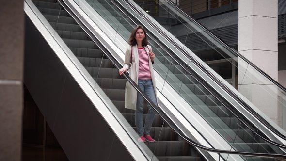 Girl Goes down the Escalator in the Store, Stock Footage | VideoHive