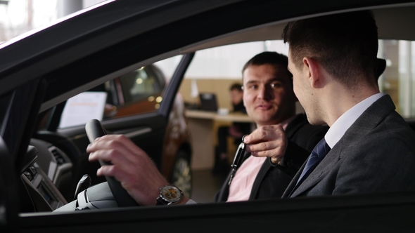 Car Dealer Gives the Customer the Car Keys in Car