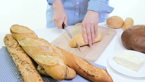Fresh Bread Slice and Cutting Knife on Rustic Table. With Wooman Hands alt