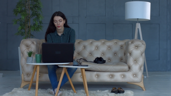 Freelance Woman on Sofa Suffering Headache at Home alt
