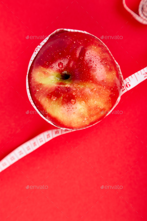 Measuring tape wrapped around a red apple - Stock Photo - Images