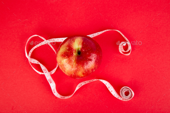 Measuring tape wrapped around a red apple - Stock Photo - Images