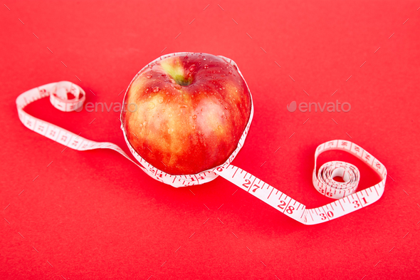 Measuring tape wrapped around a red apple - Stock Photo - Images