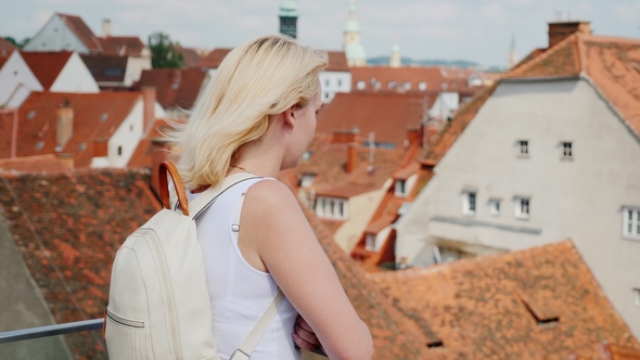 A Young Woman Tourist Is Admiring the Old European City From a Height. Graz, Austria. Tourism in alt