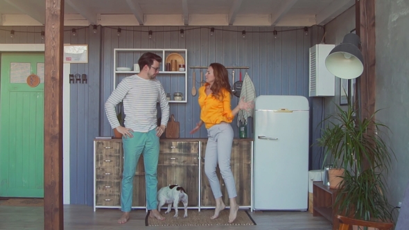 Happy Young Couple and French Mastiff Dancing in the Kitchen.