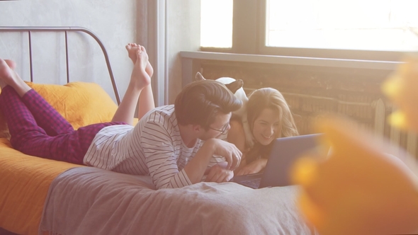 Happy Young Couple with French Dog with Laptop at Home alt