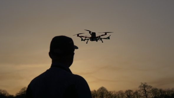 Man Silhouette Drone Control at Sunset