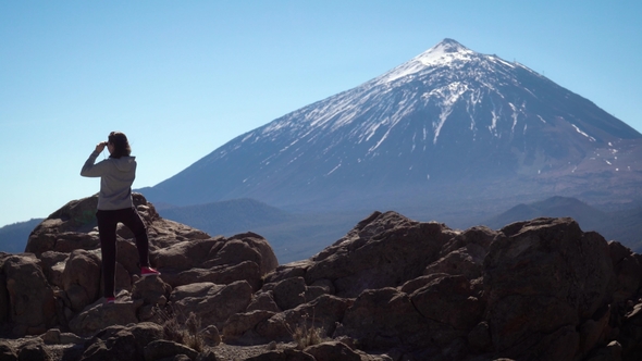 Tourist Looks at the Teide Volcano with Binoculars alt