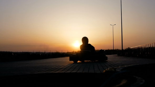 Race on Karting at Sunset. Racing Circuit in the Evening. Guys in Helmets Compete for Speed. Cars