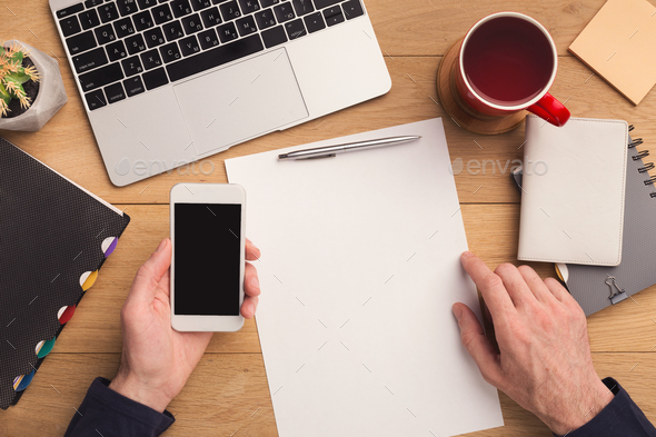Man writing letter and holding smartphone - Stock Photo - Images