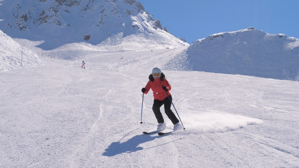 Sporty Woman Skis Carving Down The Slope In The Mountains Ski Resort At Winter alt